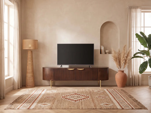 Meuble TV bas en bois massif NEVILI dans un salon bohème lumineux aux tons chauds, vue de face