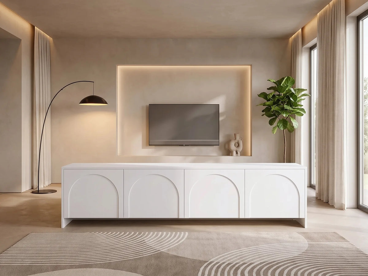 Meuble TV Blanc 4 Portes Arrondies 200 cm NALYRA dans un salon moderne lumineux aux tons chauds, vue de face