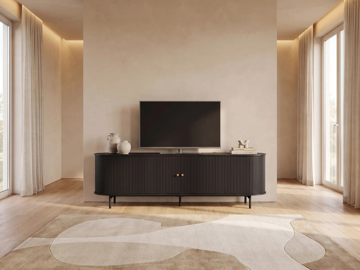 Meuble TV sur Pieds Noir Arrondi 2 Portes Coulissantes 180 cm SEVATO dans un salon minimaliste lumineux aux tons chauds, vue de face